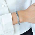 14k white gold gemstone bracelet styled on a wrist, highlighting how the blue topaz catches the light.