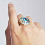 Lifestyle shot of rotating blue topaz spinner ring on female hand