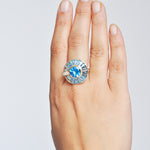 Blue topaz spinner ring worn on finger luxury jewelry model shot