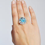 Hand model showcasing 14K gold rotating blue topaz statement ring