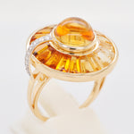 Artistic shot of the gold citrine ring resting on a textured surface with warm, natural lighting.