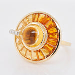 Macro detail of the channel setting holding tapered baguette citrines around a smooth central cabochon.