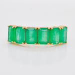 High-magnification image of the emerald ring face, showing the texture and brilliance of the stones.