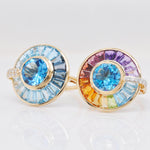 Two luxury spinner rings with blue topaz and rainbow gemstones