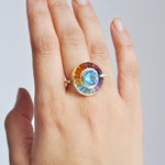 Hand model showcasing 14K gold rotating rainbow gemstone ring