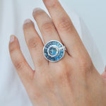 A model’s hand featuring the blue topaz and diamond ring,