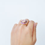 Model demonstrating the scale of the circular pink gemstone ring with a natural, elegant feel.