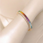 Rainbow gemstone and diamond bracelet styled on a model’s wrist.