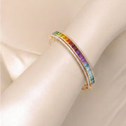 Rainbow gemstone and diamond bracelet styled on a model’s wrist.
