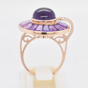 Circular amethyst cluster ring in a 14K rose gold setting, featuring a dome cabochon and baguette cuts.