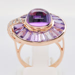 A tight shot showcasing the smooth cabochon texture and the geometric cuts of the surrounding amethyst stones.