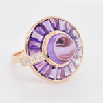 Macro shot of the central amethyst cabochon, the precise channel-set tapered baguettes, and diamond details.