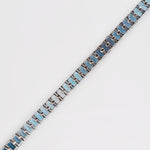 Diagonal view from behind, showing the linked white gold setting of the blue topaz gems.