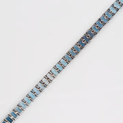 Diagonal view from behind, showing the linked white gold setting of the blue topaz gems.
