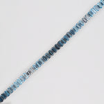Diagonal overhead shot displaying the seamless gradient from light blue topaz to dark blue topaz in a white gold bracelet.
