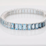 Detailed texture shot of the 14k white gold prongs holding the blue topaz stones.