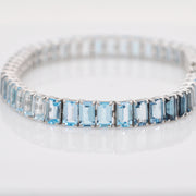 Detailed texture shot of the 14k white gold prongs holding the blue topaz stones.