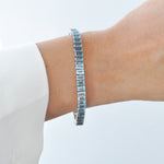 Bracelet with blue toapz gemstones on a model's wrist.