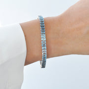 Bracelet with blue toapz gemstones on a model's wrist.