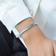 Blue topaz and 14k white gold bracelet worn on a wrist to show scale and drape.