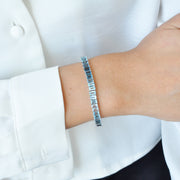 14k white gold gemstone bracelet styled on a wrist, highlighting how the blue topaz catches the light.