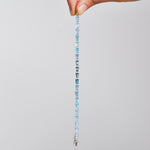 Blue topaz bracelet held in hand showing the light & dark blue gemstones.