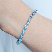 Model’s wrist wearing the 14K white gold blue topaz and diamond bracelet to demonstrate its elegant drape and sparkle.