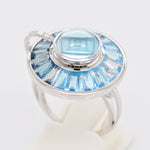 Focused photograph showing the bezel and channel-set blue topaz, showcasing fine jewelry craftsmanship.
