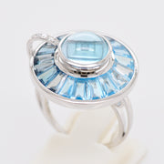 Focused photograph showing the bezel and channel-set blue topaz, showcasing fine jewelry craftsmanship.