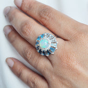 A model’s hand wearing the 14K white gold opal and blue topaz statement ring on the middle finger.