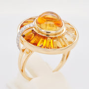 Artistic shot of the gold citrine ring resting on a textured surface with warm, natural lighting.