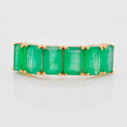 High-magnification image of the emerald ring face, showing the texture and brilliance of the stones.