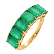 A classic 14K gold eternity style ring featuring vibrant green emeralds in prong settings.