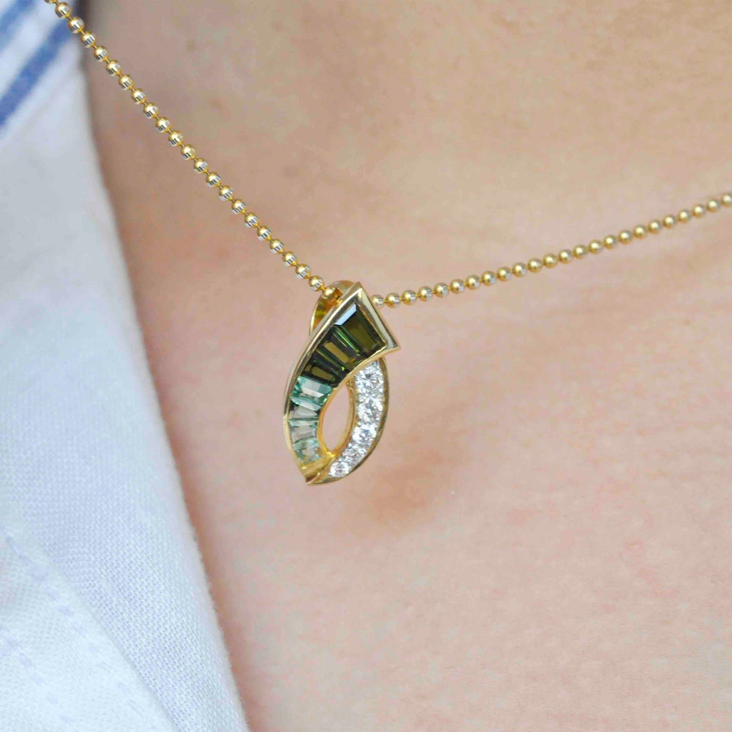 green tourmaline and diamond pendant with a curved design