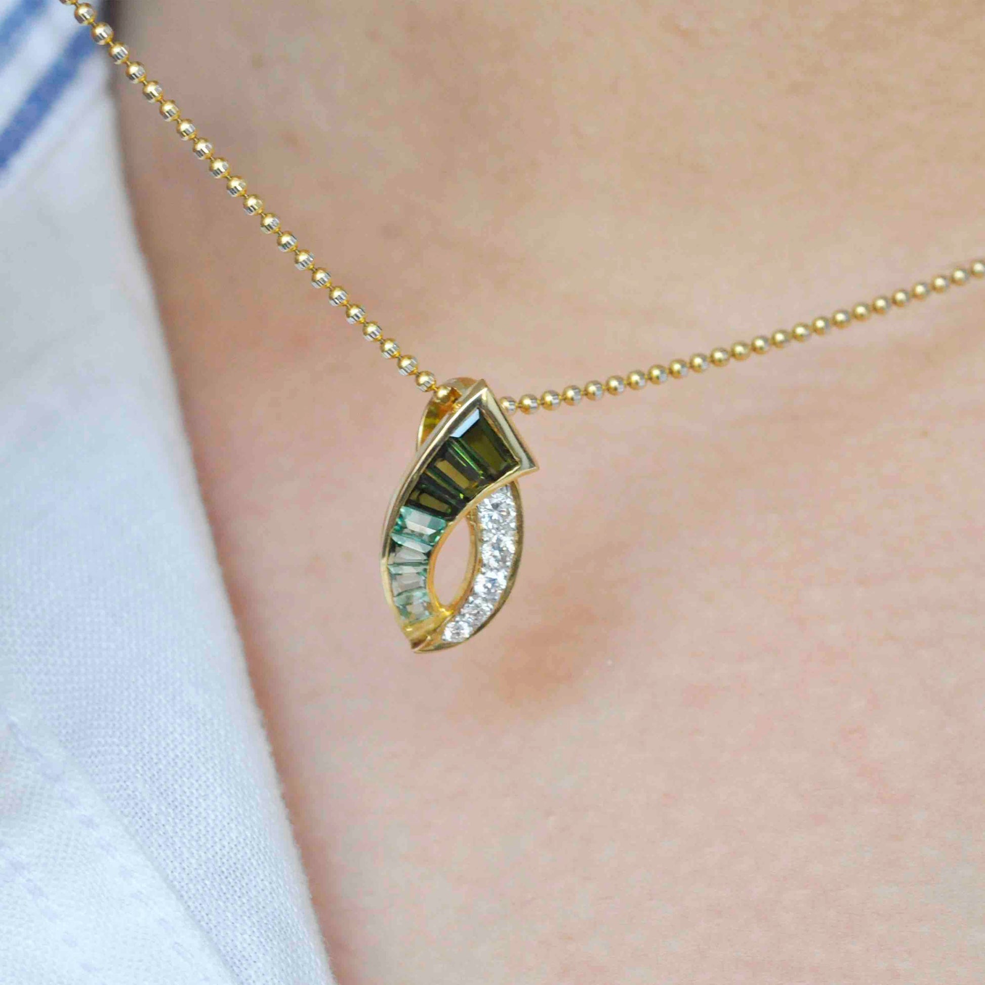 green tourmaline and diamond pendant with a curved design