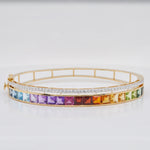 Macro close-up showing the precise channel-set channel of multicolor square-cut gemstones and the adjacent pavé diamond row in 14K yellow gold.