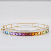 Macro close-up showing the precise channel-set channel of multicolor square-cut gemstones and the adjacent pavé diamond row in 14K yellow gold.