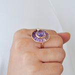 Close-up of a hand displaying the unique rotating amethyst statement ring.