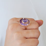 Close-up of a hand displaying the unique rotating amethyst statement ring.