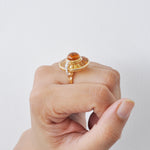 Model shot demonstrating how the light catches the rotating baguette-cut citrines on the finger.