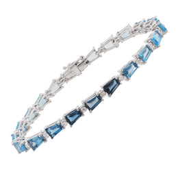 Front view of a luxury white gold bracelet displaying the transition from light blue sky topaz to deep blue London topaz.